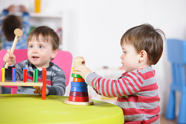 istock Twin Boys Playing With Multi-coloured Wooden Toys 184152634