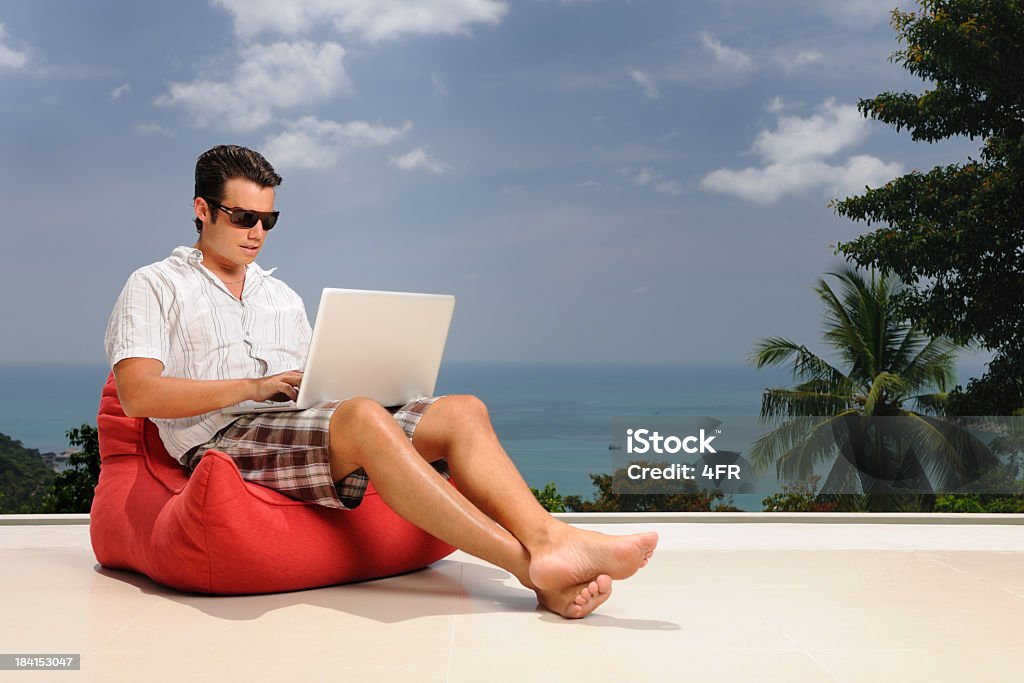 Un hombre de negocios trabajando en vacaciones (XXXL - Foto de stock de Hombres libre de derechos