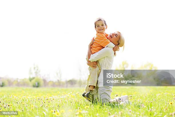 Madre Y Su Hijo Rodeado De Un Parque Foto de stock y más banco de imágenes de Abrazar - Abrazar, Adulto, Adulto de mediana edad