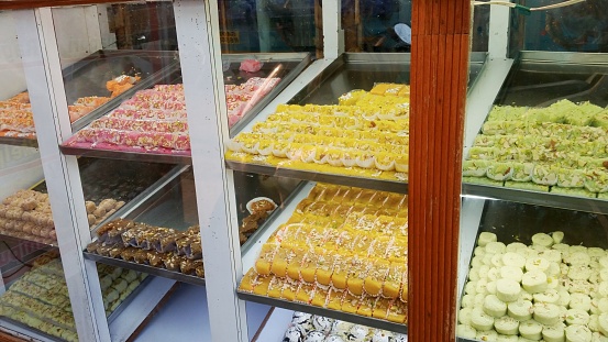 Vibrant display of Indian pastries in a local bakery, tempting with a delightful array of sweet treats.