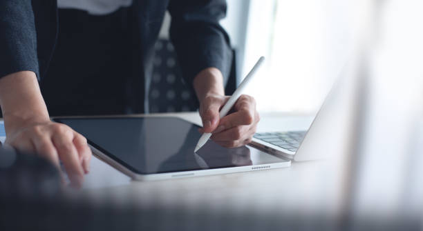 istock Businesswoman using stylus pen signing on digital tablet via mobile app, proofing e-document on office table. Business woman, project manager planning and working on computer, business technology 1841543179