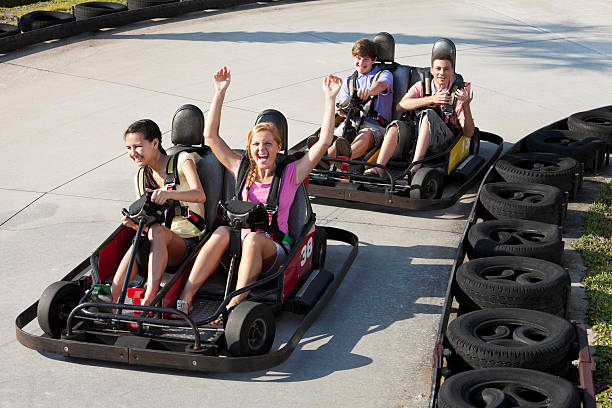 Teenagers riding go-carts Teenage friends, 14 to 16 years, riding go-carts. go carting stock pictures, royalty-free photos & images