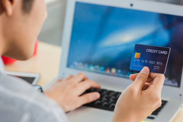 istock business man hand holding credit card and typing entering security code on a laptop computer 1841595722