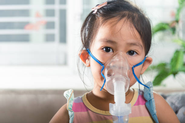 istock Asian Child using nebulizer mask equipment alone have smoke 1841597320