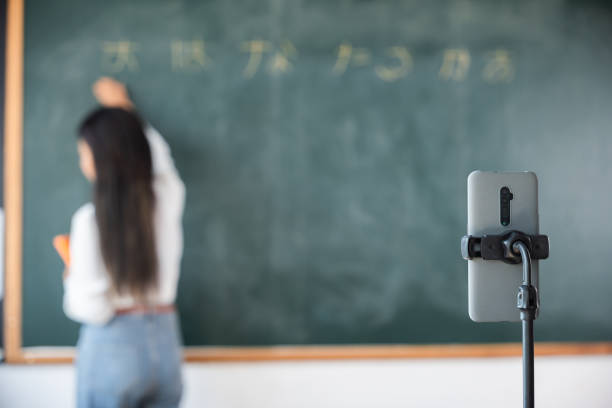 istock Asian teacher teach on board while have blackboard lecture online through smartphone in classroom 1841597334