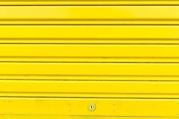 istock Bright yellow metal sliding door with key hole 184167430