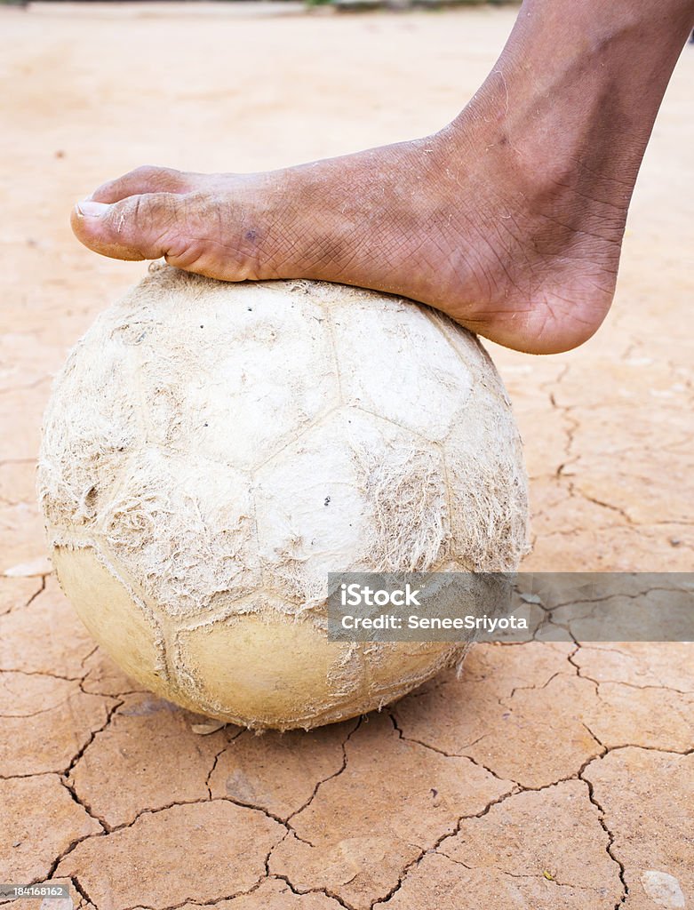 Barefoot on old football. Barefoot Stock Photo