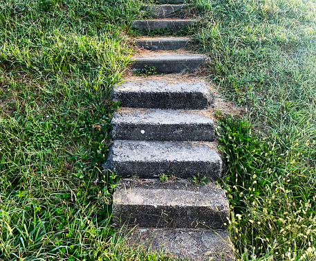 Old stone steps on a grassy bank in a campsite in France. October 2023