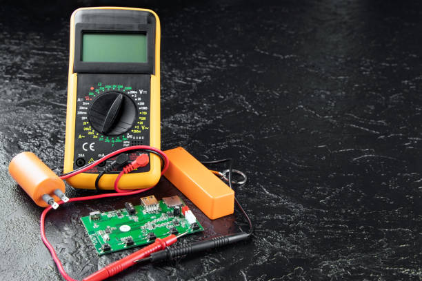 istock Digital multi-meter with probes on a black stone background. Multitester and microcircuit. Voltage Tester. Copy space. Voltmeter. Measuring tool. DMM. 1841810034