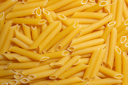 Uncooked Penne Rigate Pasta Background