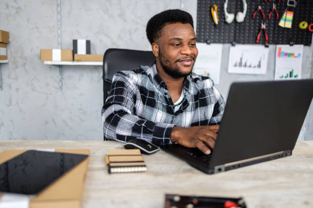 istock Smiling man using laptop in retail place 1841851343