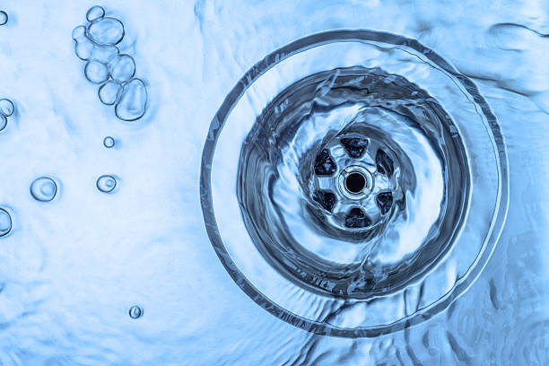 Close-up of water draining in an aluminum kitchen sink Kitchen sink, running water (light blue) kitchen sink stock pictures, royalty-free photos & images