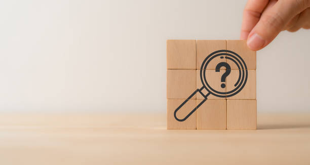 istock Magnifying glass and question mark icon on wooden cube blocks. Question mark, problems and root cause analysis concept. Define problems to find solution. Finding answers, trends, opportunities. 1841887157