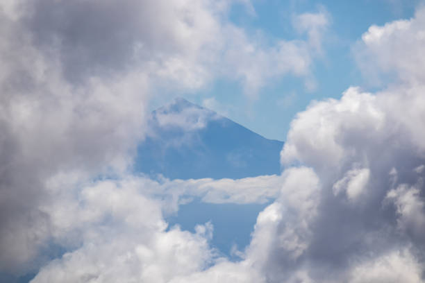 Scenic view on the cloud covered volcano mountain peak Pico del Teide on Tenerife seen from La Gomera, Canary Islands, Spain, Europe. Mystical magical atmosphere on hiking trail to Roque de Agando