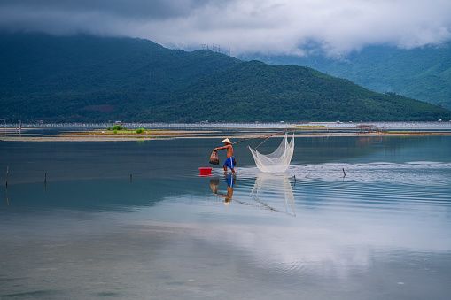 Fisherman in Lap An lagoon is pulling fishing trap on the water - Lap An, Lang Co town, Thua Thien Hue province, central Vietnam