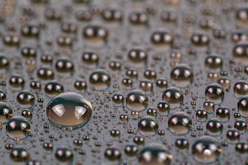 water drops on surface of screen of cellphone, close-up with selective focus and blur