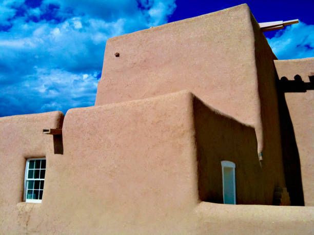 Rancho de Taos, New Mexico, USA - August 15, 2020: Side view of the historic San Francisco de Asis Catholic Church on a sunny summer day.