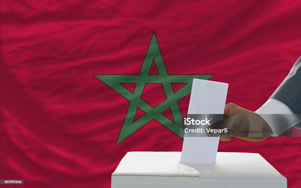 Homme vote sur les élections au Maroc de drapeau sur le devant. - Photo de Maroc libre de droits