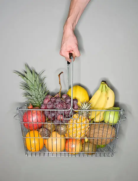 Holding a shopping-basket of fruit