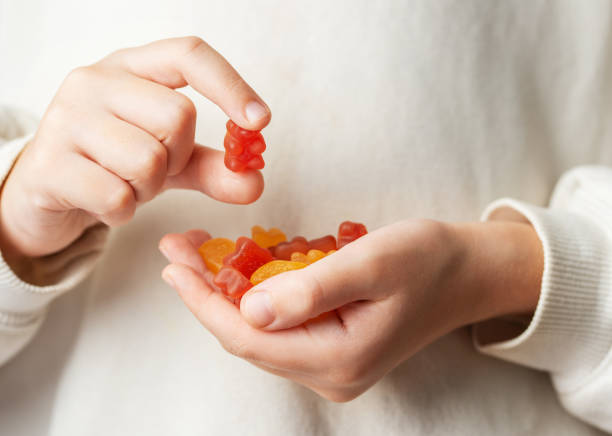 istock A girl holds a gummy bear vitamines in her hands 1842005482