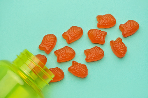 Vitamins for children,   jelly gummy fesh candy on pastel green  background