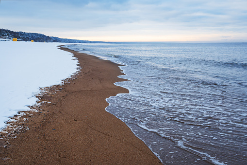 The sunsets on a sandy beach bathed in the golden rays of the setting sun.