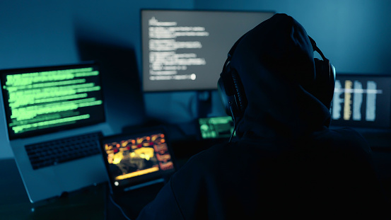 Hacker using computer breaks into government data servers and infects their systems with a virus. Hacker breaks into a corporate data server. Cyber crime, Digital system security