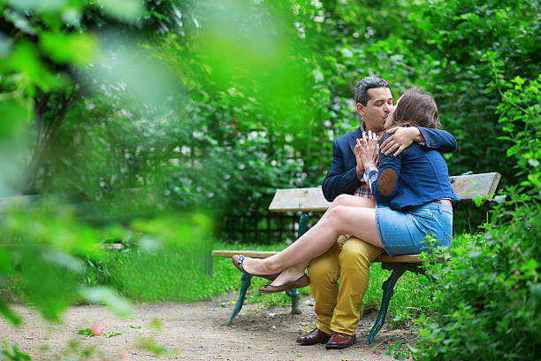 Young loving couple kissing on a bench