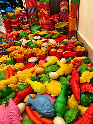 A pile of plastic toys sitting on top of a table. Beautiful picture of fruits and toys colorful plastic.