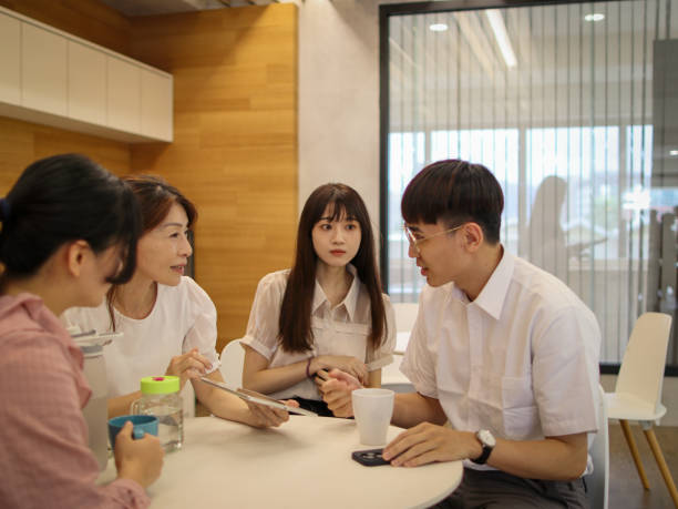 istock A mature female supervisor explains the work plan to several young employees with a digital tablet 1842037698