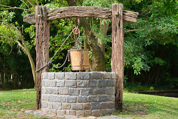 Antique Water Well Antique Water Well With a Rope and a Bucket wells stock pictures, royalty-free photos & images