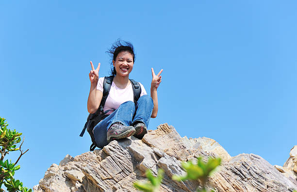 istock young woman hiker sit on mountain rock 184205724
