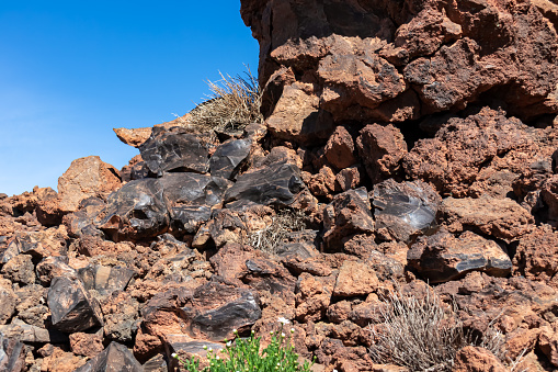 Pile of volcanic rocks. Some stones broke open showing smooth surface. Hiking trail leading to the summit of volcano Pico del Teide, Mount Teide National Park, Tenerife, Canary Islands, Spain, Europe