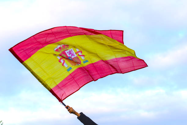 istock Holding Spanish flag waving over the sky 1842116680
