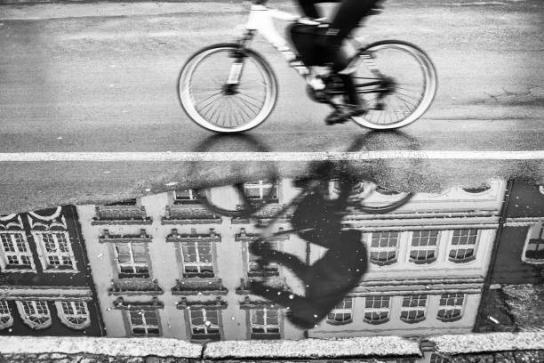 A bicycler passes a street puddle on a frigid New Year's Eve in Gdansk, Poland. Reflections of the rider, his bicycle, and a building are seen in the puddle.