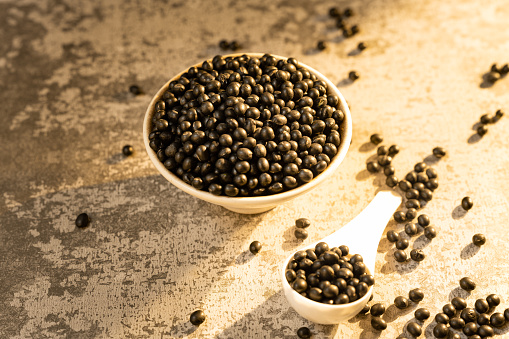 Fresh Capia peppers and chili flakes or powder in wooden spoon on grey rustic table, healthy turkish spice