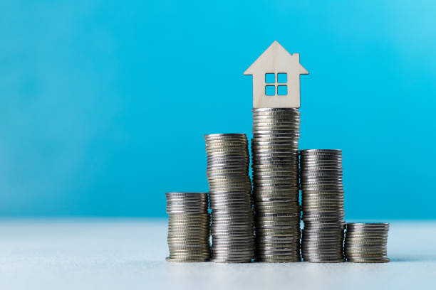 istock Wooden house on a stack of coins 1842155131