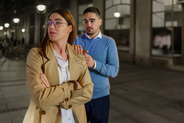 un petit ami et une petite amie pris dans une dispute animée dans les rues nocturnes - frustration women threats disappointment photos et images de collection