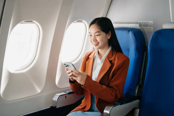 istock Young Asian executive excels in first class, multitasking with digital tablet, laptop and smartphone. Travel in style, work 1842182371