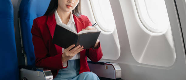 istock Young Asian executive excels in first class, multitasking with digital tablet, laptop and smartphone. Travel in style, work 1842182914