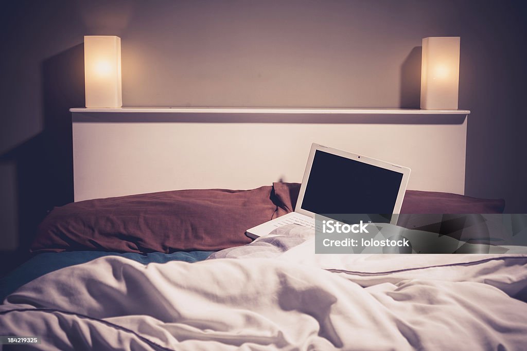 Laptop in bed at night Laptop in an unmade bed at night Bed - Furniture Stock Photo