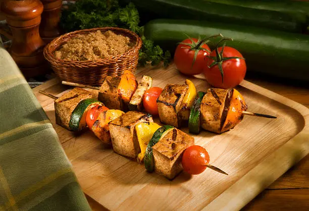 Barbecued Tofu and Vegetable skewers on Wood Background