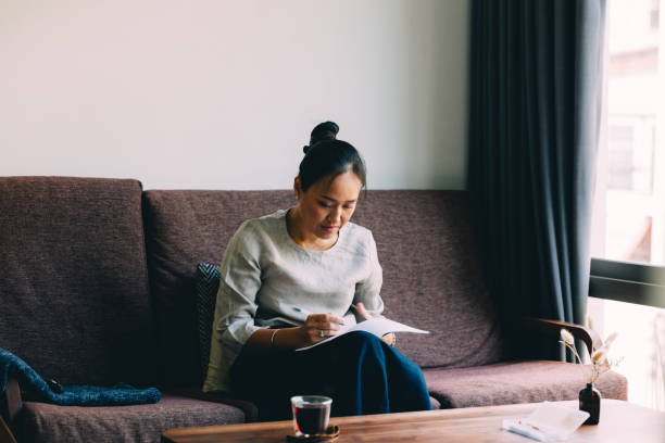 istock A Serious Beautiful Businesswoman Taking Some Notes While Relaxing At Home 1842214067