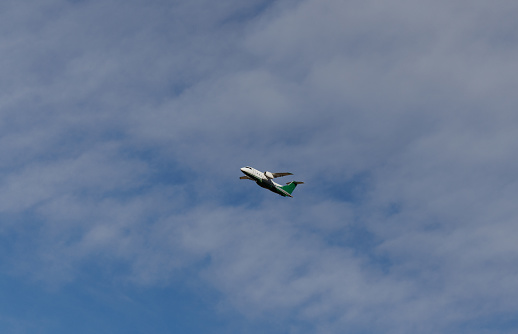 Denver, CO USA - December 4, 2023: Airplane taking off from Denver International Airport on a partly cloudy winter day.