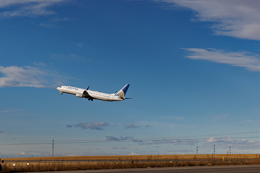 Denver, CO USA - December 4, 2023: Airplane taking off from Denver International Airport on a partly cloudy winter day. United Airlines