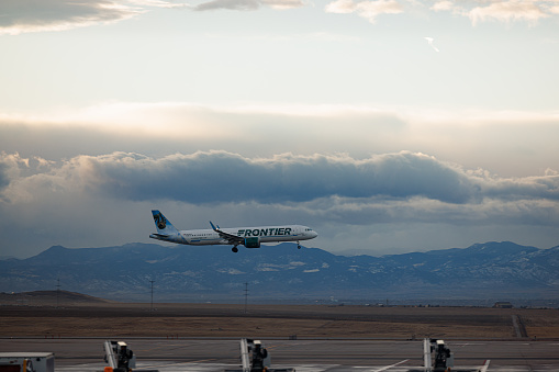 Denver, CO USA - December 4, 2023: Airplane taking off from Denver International Airport on a partly cloudy winter day. Frontier Airlines