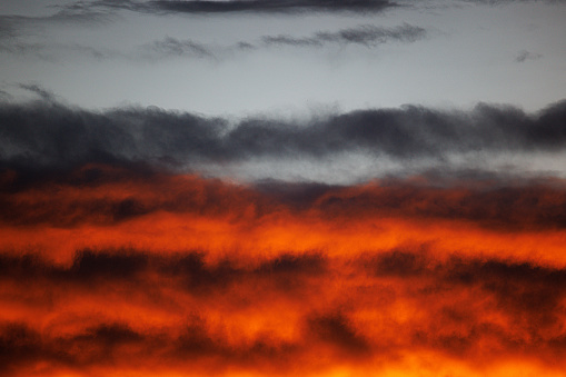 cloudy sky in dramatic orange sunlight during the sunset period. Nature, background and texture photo.