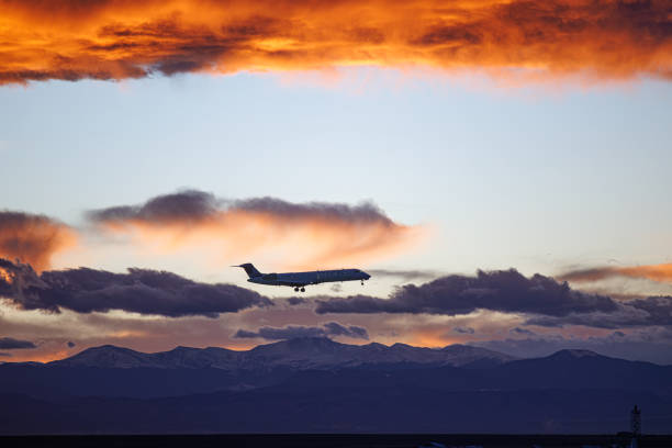 istock Airline landing plane at sunset with dramatic clouds and mountain range in the background 1842236243