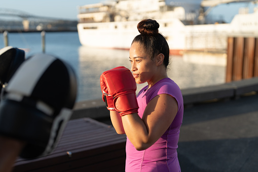 fit woman practicing boxing on marina