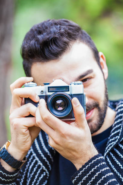 istock Portrait of a young man using a vintage camera. 1842255515